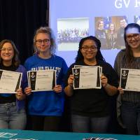 Six students showing their I am GV certificates.